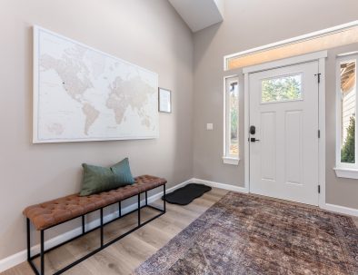 Front entry with world map art and craftsman-style door at Trail House
