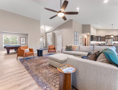 Living area with pool table, kitchen, and vaulted ceilings at Trail House golf rental