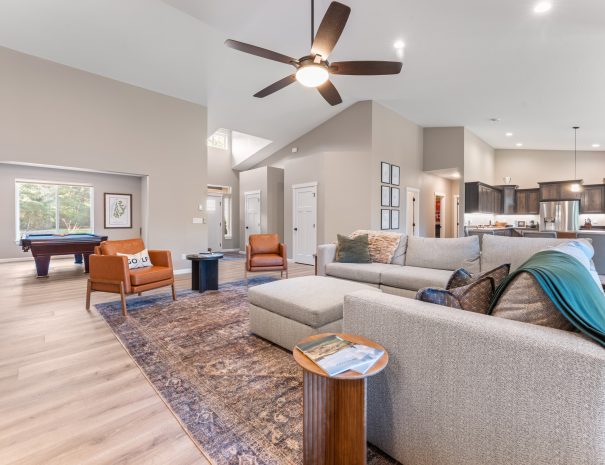 Living area with pool table, kitchen, and vaulted ceilings at Trail House golf rental