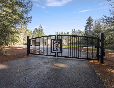 Custom iron entry gate with Trail House crest at Bandon Dunes vacation rental