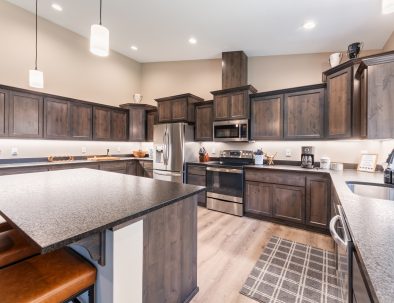 Spacious kitchen with dark wood cabinets and pendant lighting at Bandon's Trail House