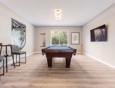 Pool room with custom table, wall-mounted TV, and Trail House logo mural