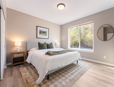 Comfortable king bedroom with large windows overlooking forest at Bandon's Trail House vacation rental