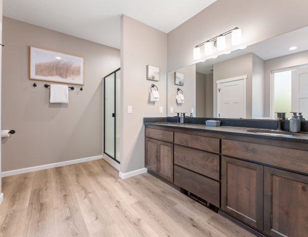 Spa-like master bathroom with double vanity, walk-in shower, and skylight at Trail House golf rental