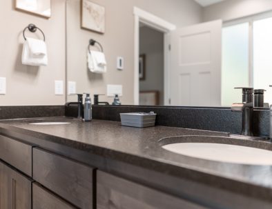 Dual-sink guest bathroom with quartz countertop and modern finishes at Bandon's Trail House