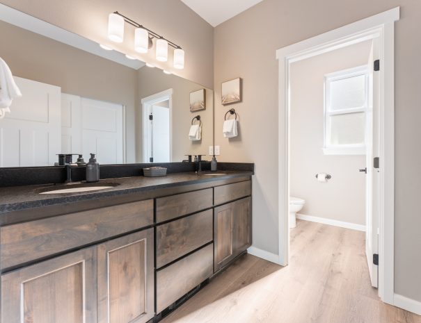 Spacious guest bathroom with vanity, toilet, and walk-in shower at Trail House golf rental near Bandon Dunes