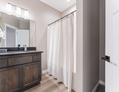 Guest bathroom with single vanity, shower, and wood cabinetry at Bandon Dunes rental house