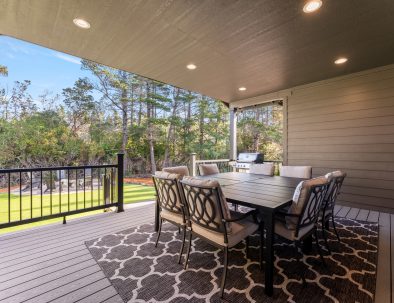 Covered deck with dining table and forest views at Trail House golf rental near Bandon Dunes