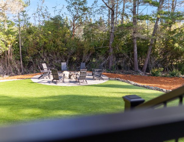 Backyard fire pit with seating on manicured lawn at Trail House golf rental near Bandon Dunes