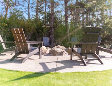 Fire pit seating area with Adirondack chairs surrounded by forest at Bandon Dunes rental house