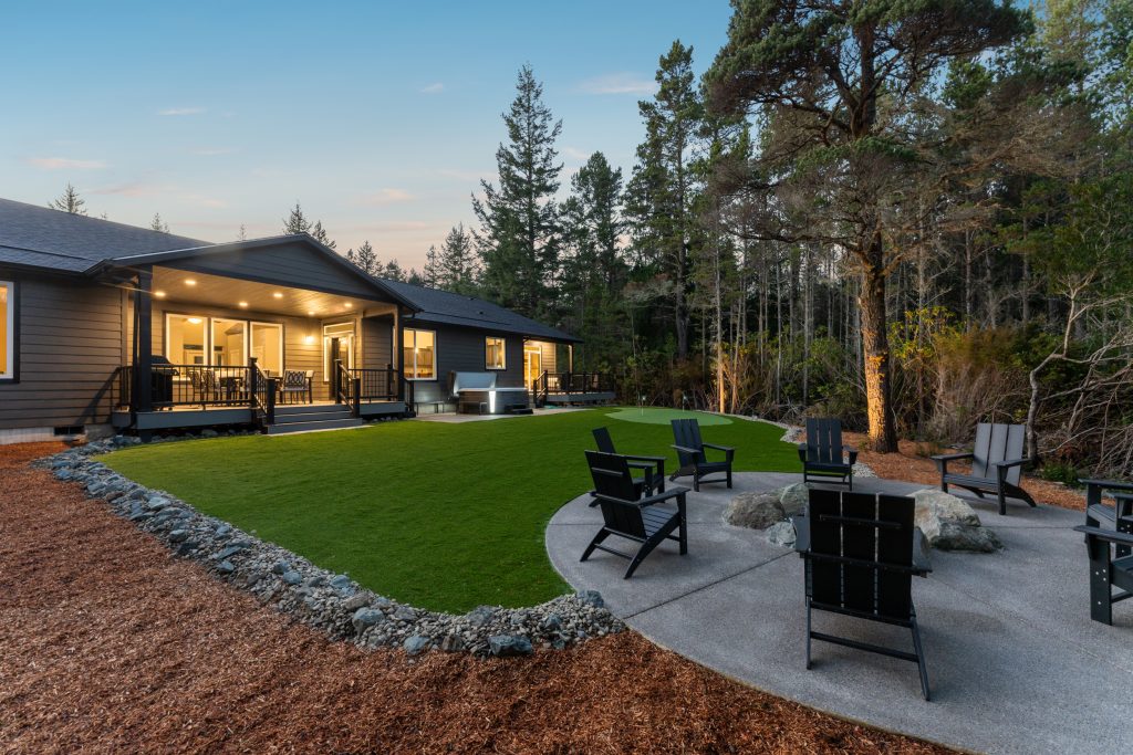 Where to stay Bandon Dunes golf trip itinerary, private vacation rental exterior dusk Oregon coast fire pit putting green.